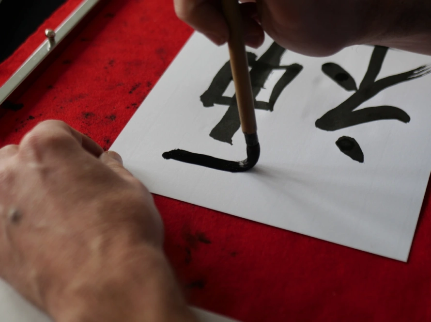 un homme qui peint des lettres chinoises
